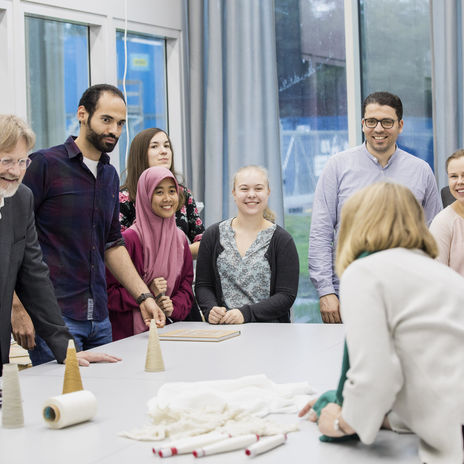 Group of people laughing aorund a table - Aalto Startup Center